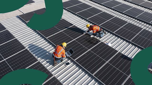 Billede af: To håndværkere der sætter solceller op på et tag